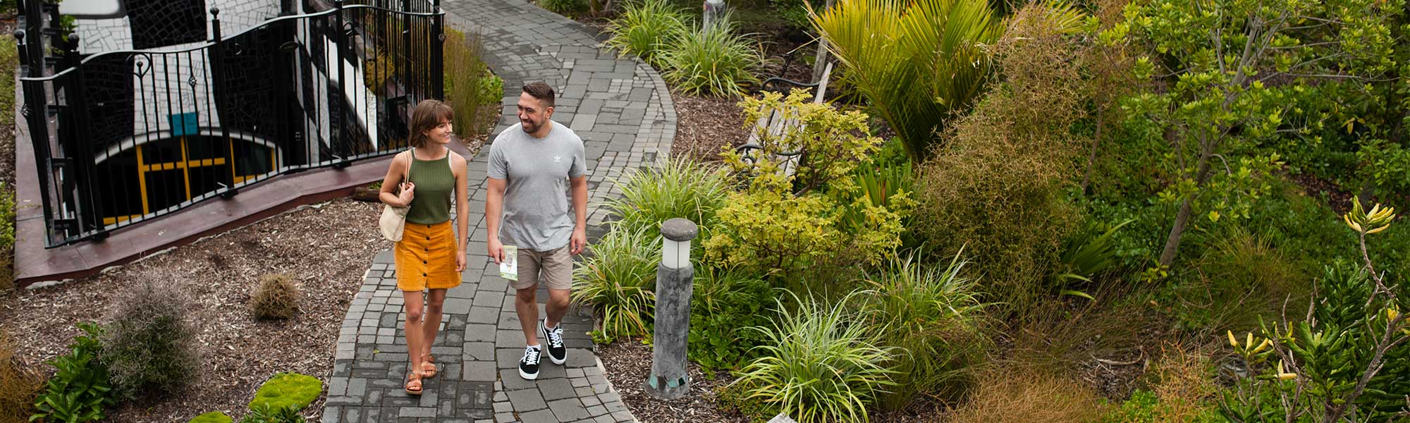 A couple walk through the afforested roof of the Hundertwasser Art Centre