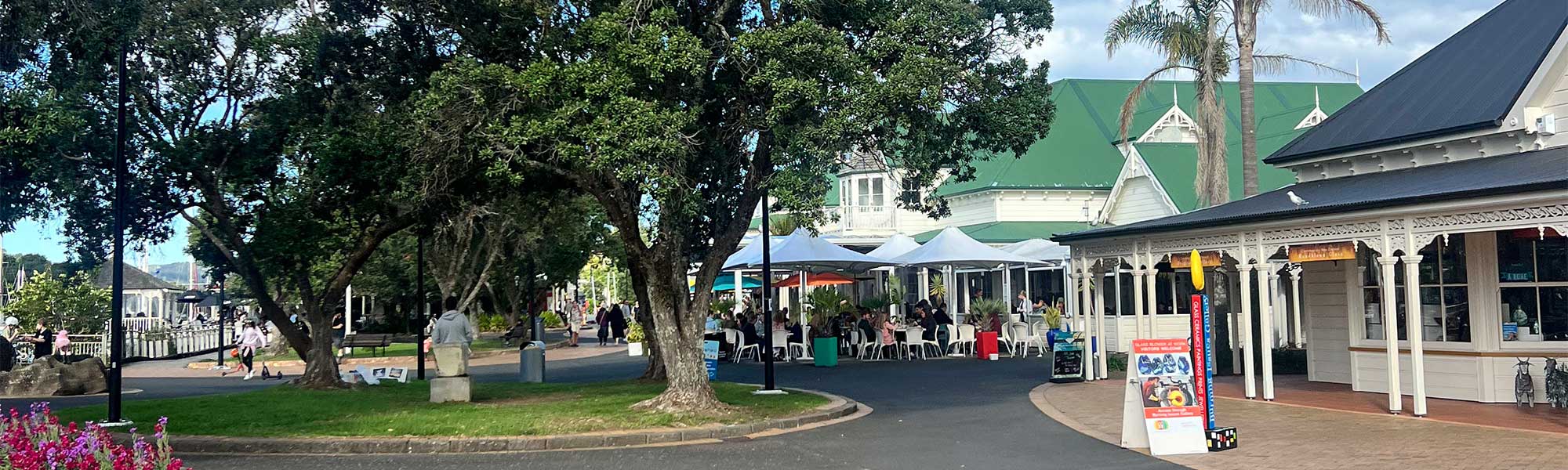 The Town Basin in Whangarei, with people walking around and signs for local galleries