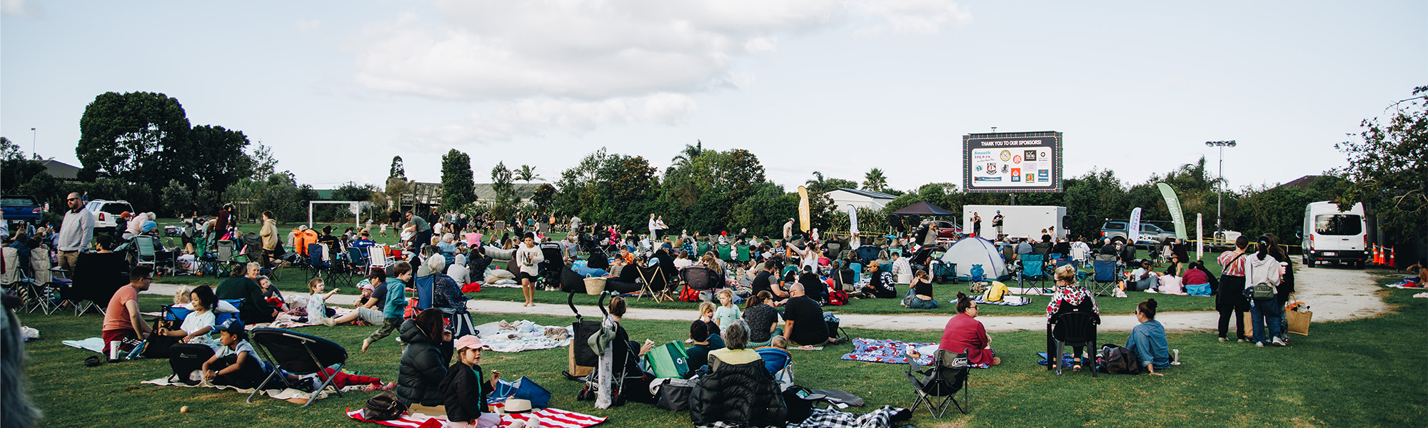 Film festival in Waipu Park with crowd of people viewing