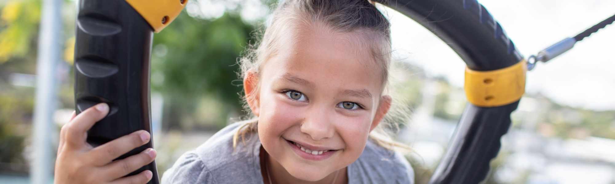 Child smiling on a tire swing. 